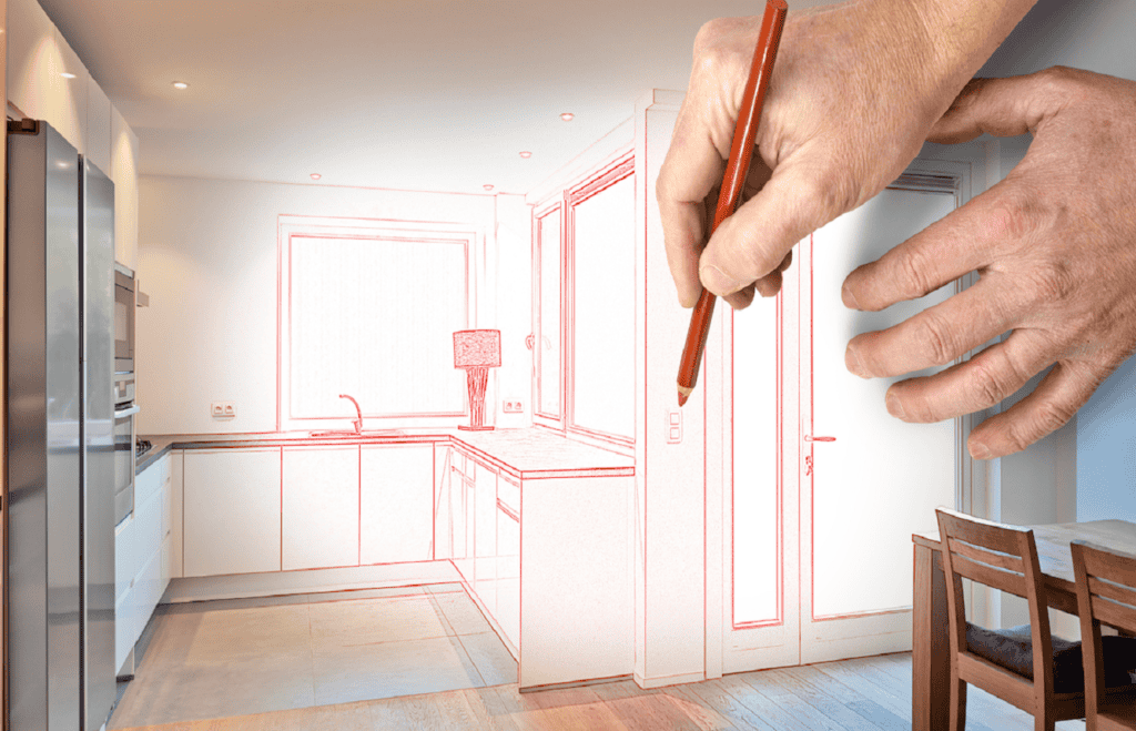 A hand sketching a modern kitchen with a pencil overlays a photograph of the same kitchen. The image shows the transition from a red line drawing to the actual modern kitchen with white cabinets, a sink, a lamp, and a wooden dining table with chairs—perfect for showcasing Kitchen Design Orlando Florida.