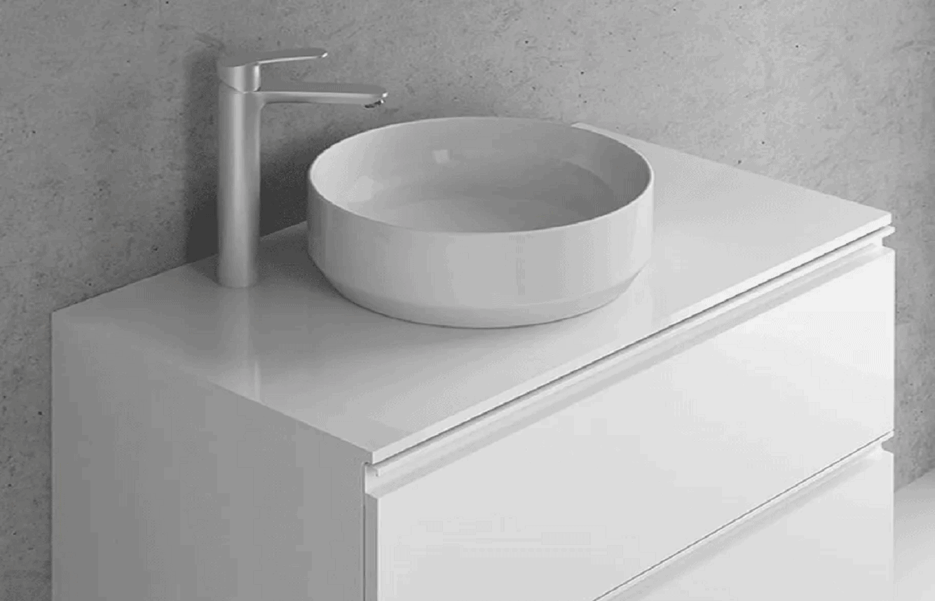 A modern bathroom vanity with a sleek design. It features a white, round vessel sink on top of a glossy white cabinet with two drawers. A tall, silver faucet is mounted to the left of the sink against a light gray wall—a perfect choice for Bathroom Remodeling Orlando Florida.